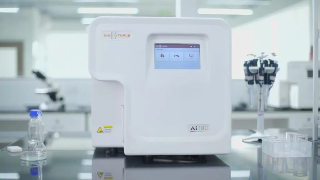 A laboratory machine with a digital display and various buttons sits on a counter next to bottles and test tubes, using AI technology to enhance medical diagnoses.