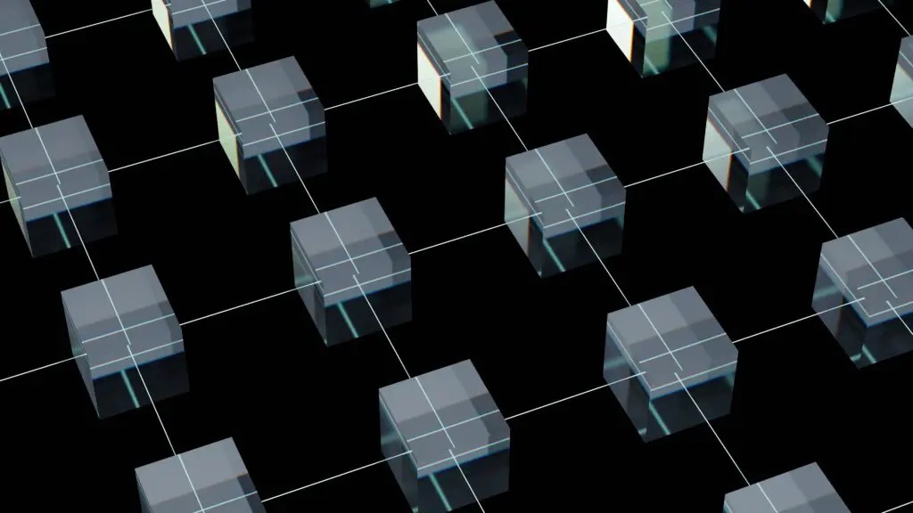 A grid of transparent glass cubes is arranged on a black surface, each cube aligned with white intersecting lines forming a geometric pattern.